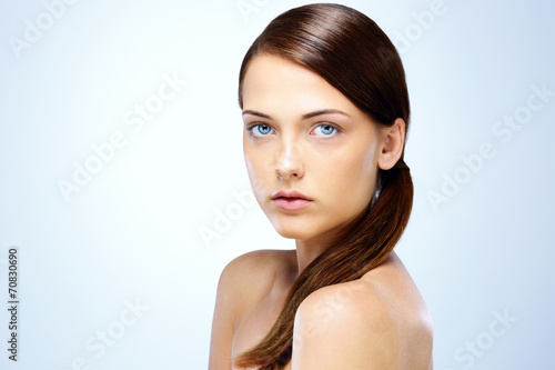Portrait of a cute young girl with fresh skin on blue background