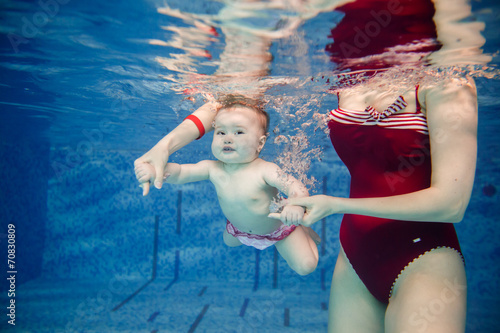 beautiful little girl swims underwater. child development
