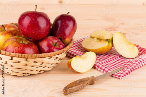 Fresh red apples in basket on wood.