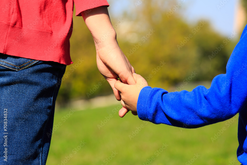 Mother holding hand of her son