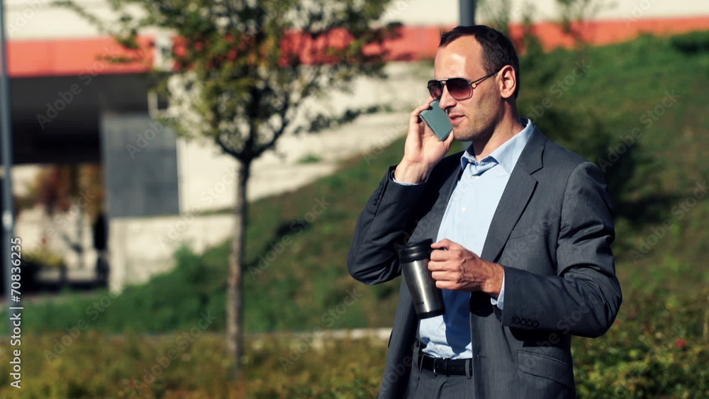 Businessman talking on cellphone and drinking coffee in the city Businessman talking on cellphone and drinking coffee in the city