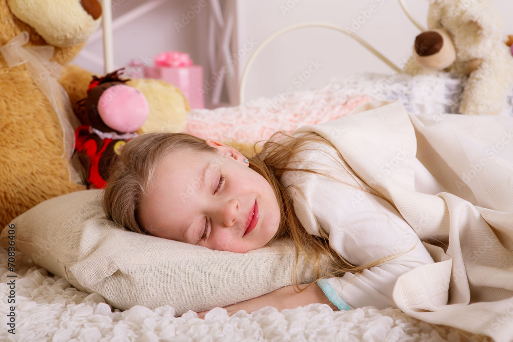 beautiful cheerful girl looks out from under a blanket beautiful cheerful girl looks out from under a blanket