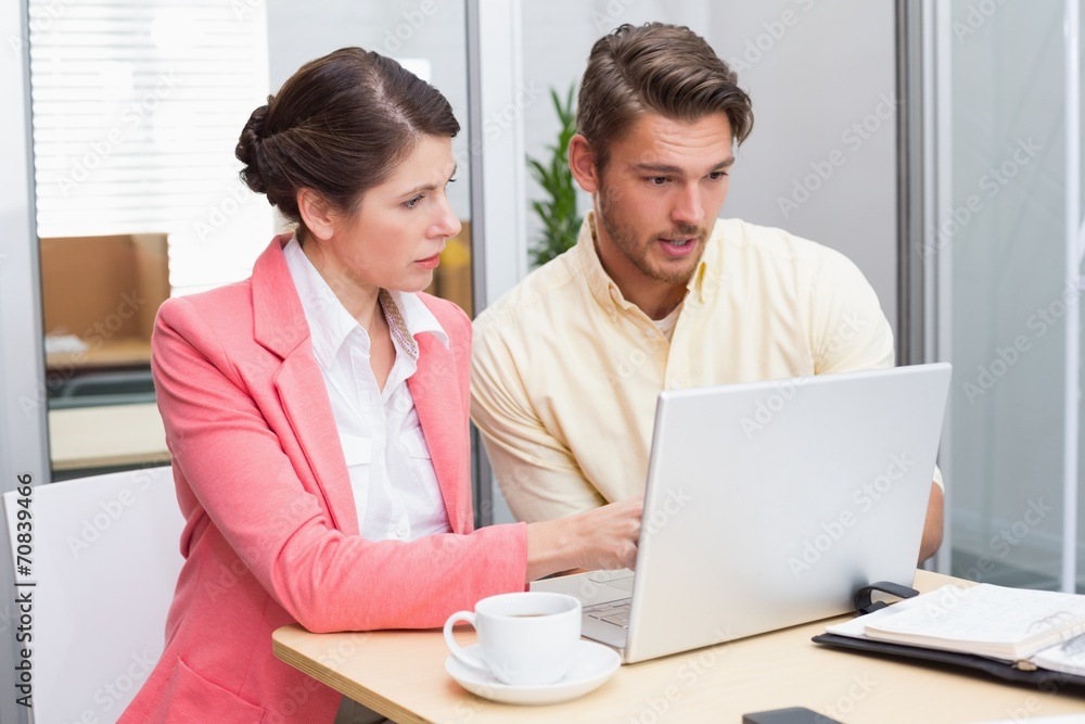Focused business people working together on laptop Focused business people working together on laptop