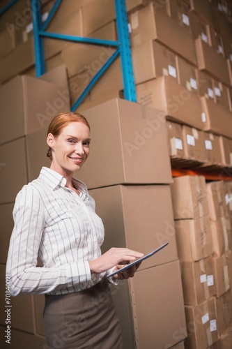 Female manager using digital tablet in warehouse