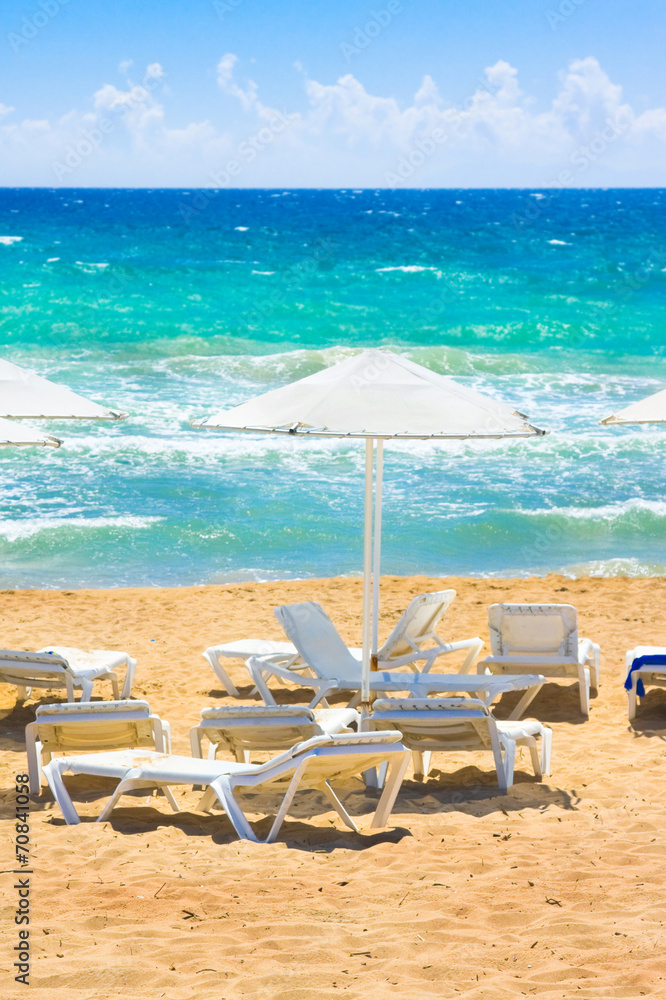 Parasols and sun loungers on the beach. Ionian Sea