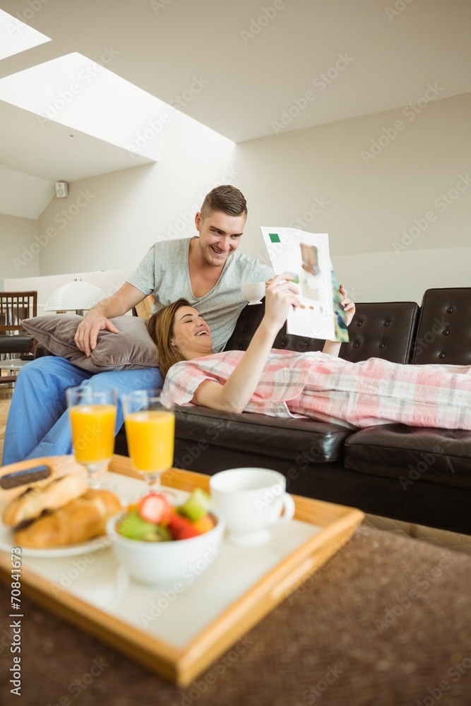 Cute couple relaxing on couch at breakfast Cute couple relaxing on couch at breakfast