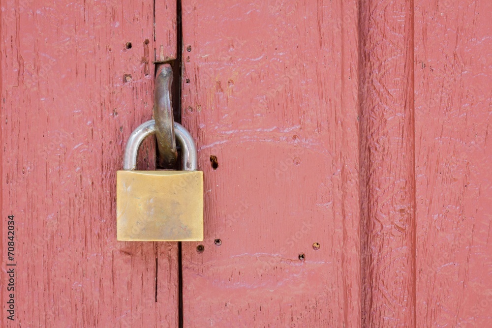 closeup of lock on the middle of pale red wood door closeup of lock on the middle of pale red wood door
