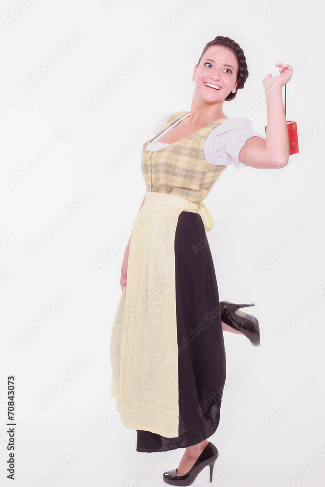 Frau im Dirndl hält ein kleines Päckchen mit dem Finger Frau im Dirndl hält ein kleines Päckchen mit dem Finger