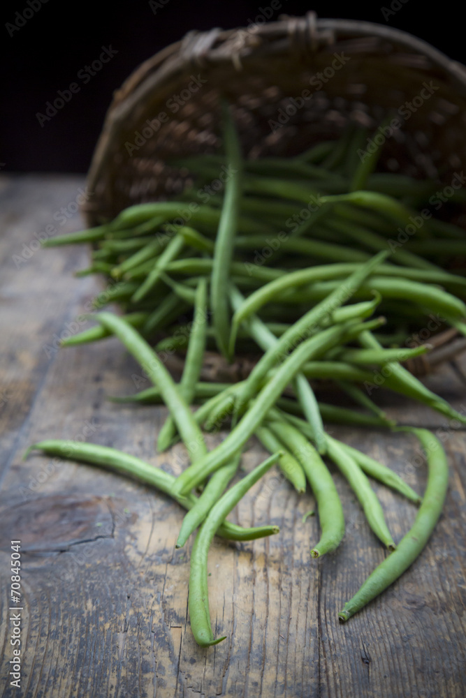 Green beans and basket on wooden table Green beans and basket on wooden table