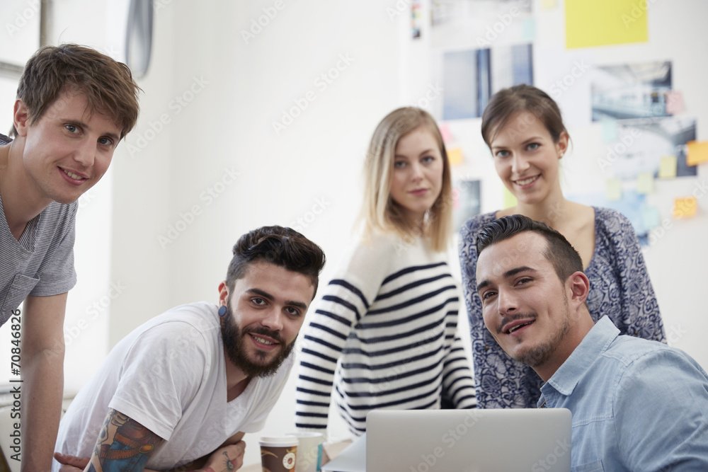 Group of creative professionals with laptop at table Group of creative professionals with laptop at table