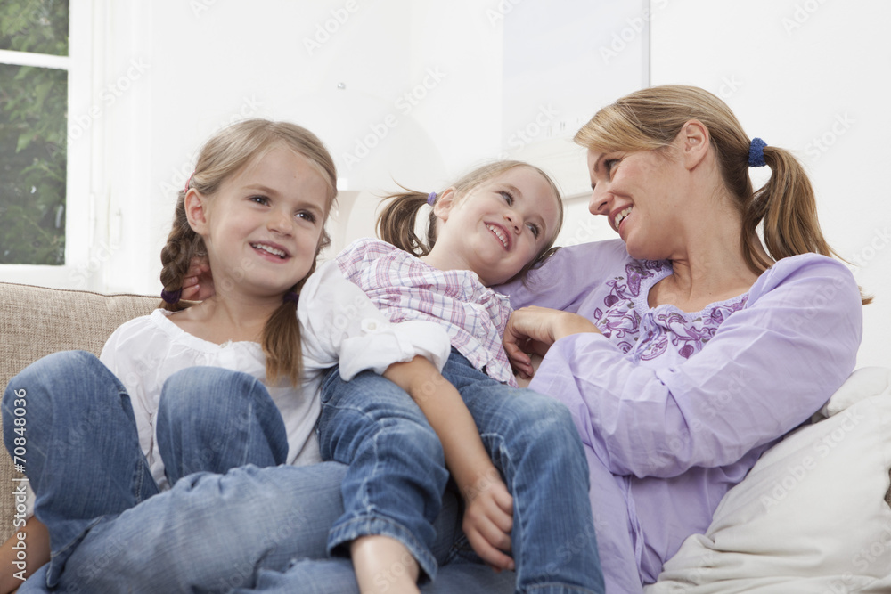 Germany, Munich, Mother with daughters resting on sofa Germany, Munich, Mother with daughters resting on sofa