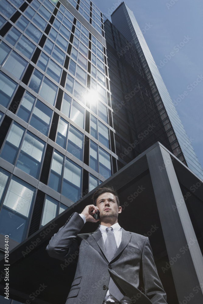 Businessman on cell phone outside office building Businessman on cell phone outside office building