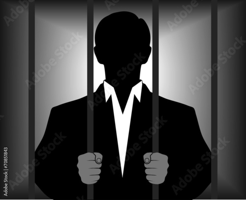 silhouette of a man behind bars