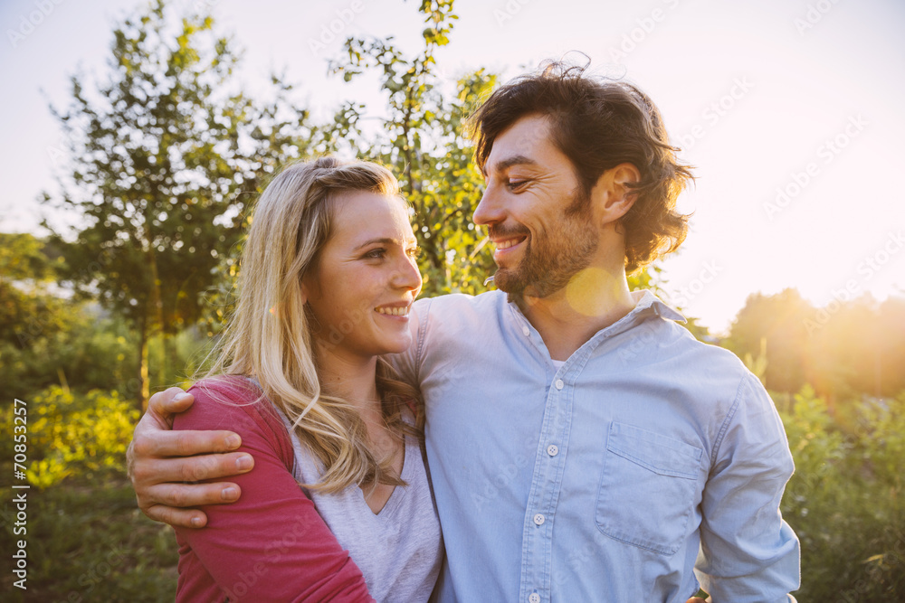 Couple hugging in garden in evening light Couple hugging in garden in evening light