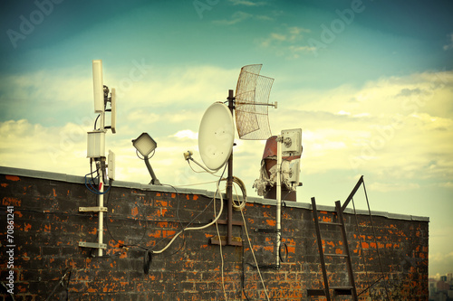 satellite dishes on the roof. Photo toned in yellow