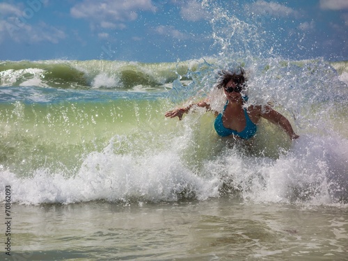 Welle überrascht junge Frau im Meer
