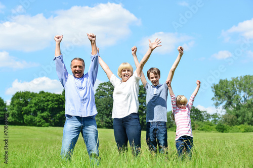 Happy family together raising their arms