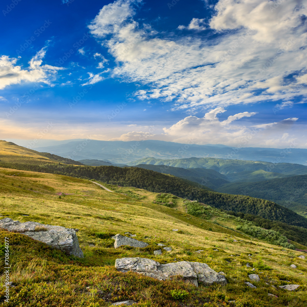 Naklejka premium light on stone mountain slope with forest at sunrise