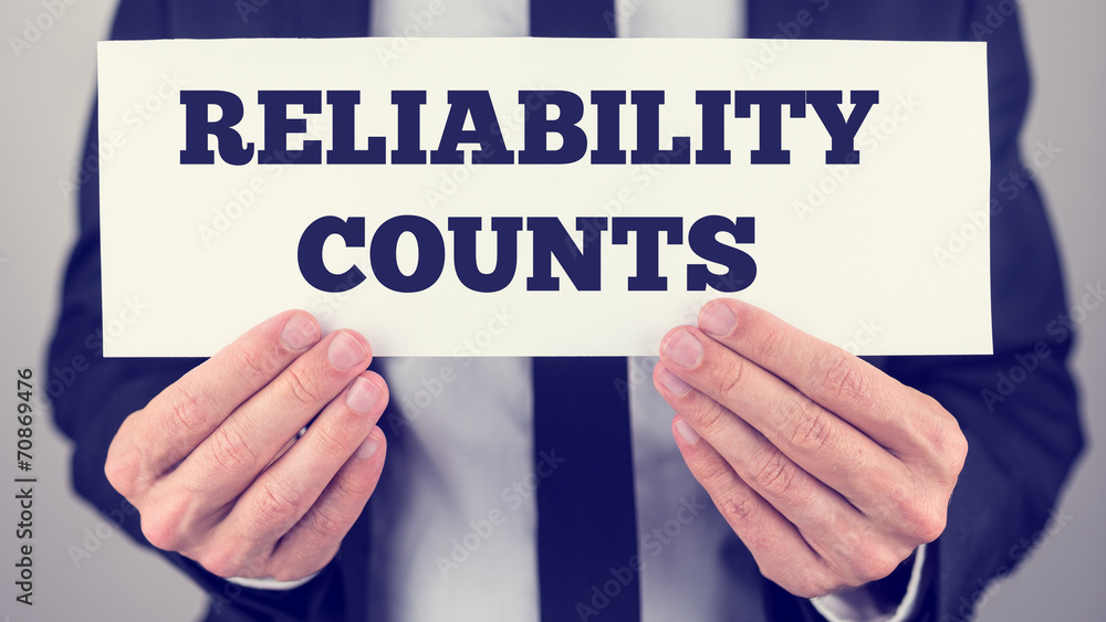 Man Holding Sign Reading Reliability Counts Man Holding Sign Reading Reliability Counts