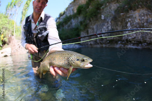 Fototapeta Naklejka Na Ścianę i Meble -  Closeup of fario trout caught in river by fisherman