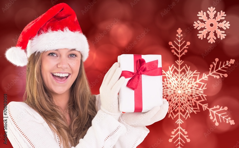 Composite image of festive blonde holding a gift Composite image of festive blonde holding a gift