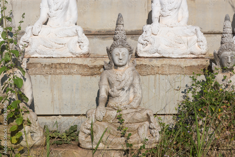 raw of white buddha status on the wall