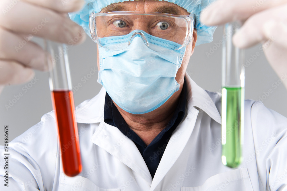 closeup of surprised man wearing mask looks at test tubes. closeup of surprised man wearing mask looks at test tubes.