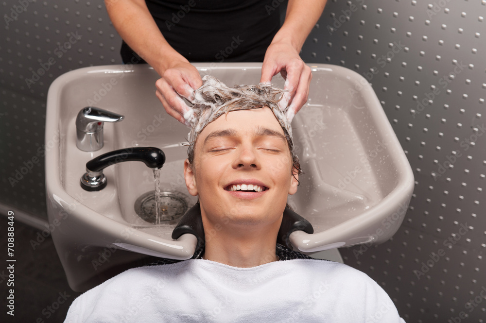 Wunschmotiv: Close-up of young smiling caucasian man having his hair washed. #70888449