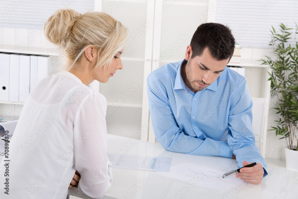 Obraz premium Beratungsgespräch: Kunde und Berater sitzend am Tisch