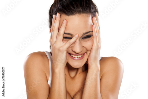 ashamed and smiling attractive woman looking through her fingers