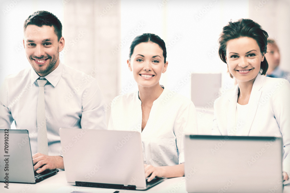 group of people working with laptops in office group of people working with laptops in office