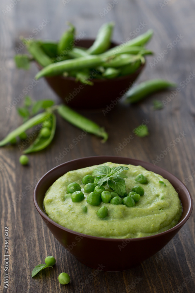 Mashed green peas and potatoes in a bowl on a wooden table Mashed green peas and potatoes in a bowl on a wooden table