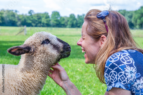 Woman and sheep heads together photo