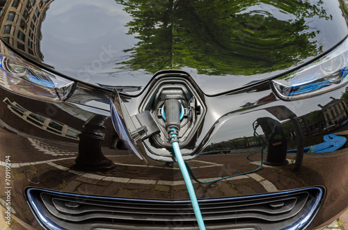 Charging modern electric car with power supply plugged in