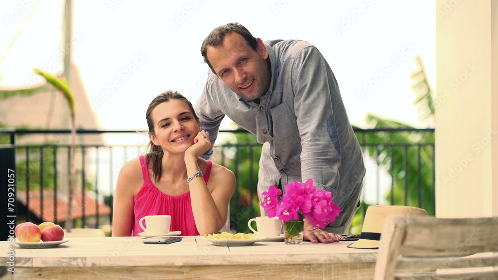 Happy couple with tablet computer by the table on terrace Happy couple with tablet computer by the table on terrace