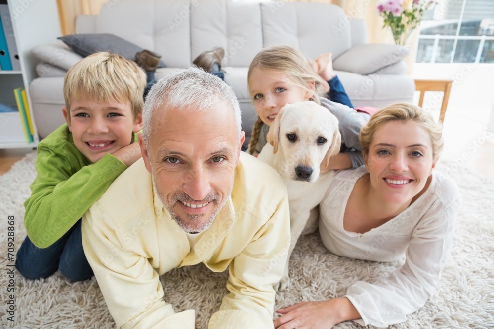 Happy parents with their children and puppy on floor Happy parents with their children and puppy on floor