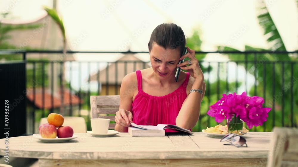 Woman talking on cellphone, explaining book that she just readin Woman talking on cellphone, explaining book that she just readin