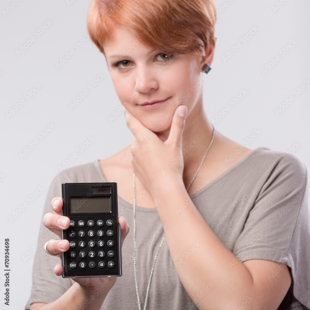Junge rothaarige Frau mit Taschenrechner Junge rothaarige Frau mit Taschenrechner