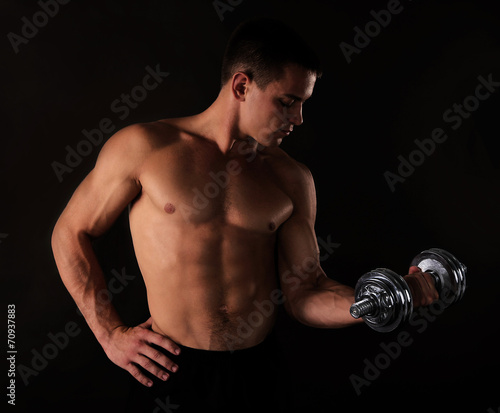 Athletic man execute exercise with dumbbells,
