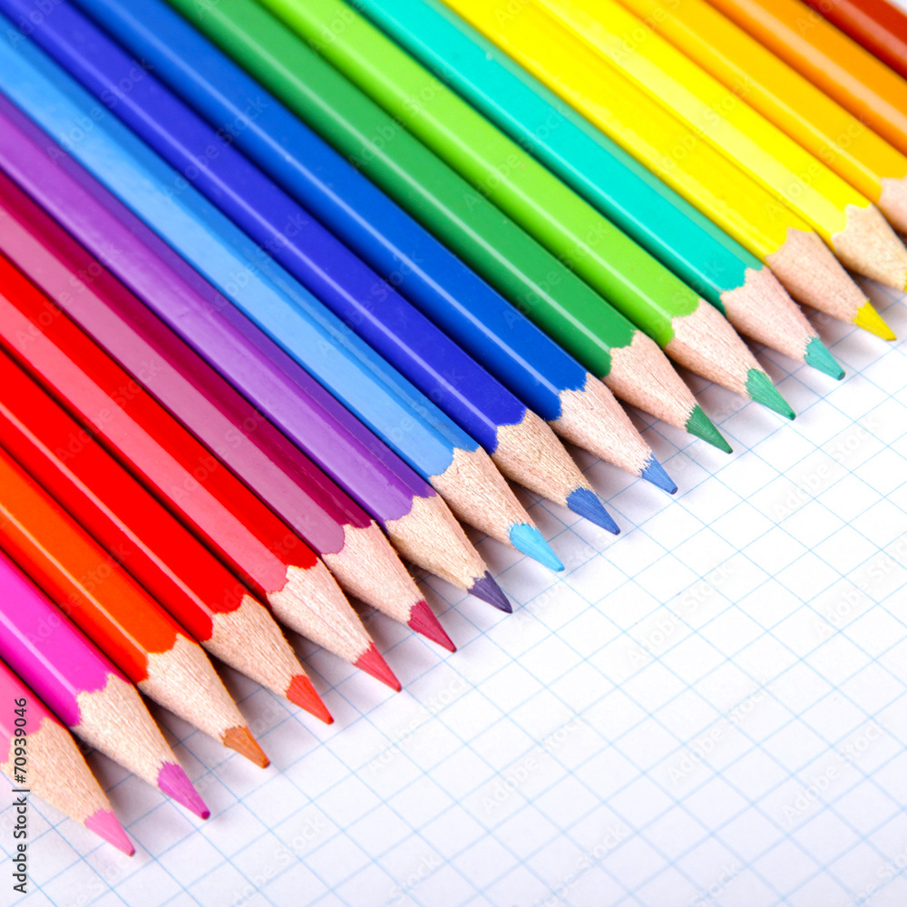 Multicolored crayons on white squared paper background. Multicolored crayons on white squared paper background.