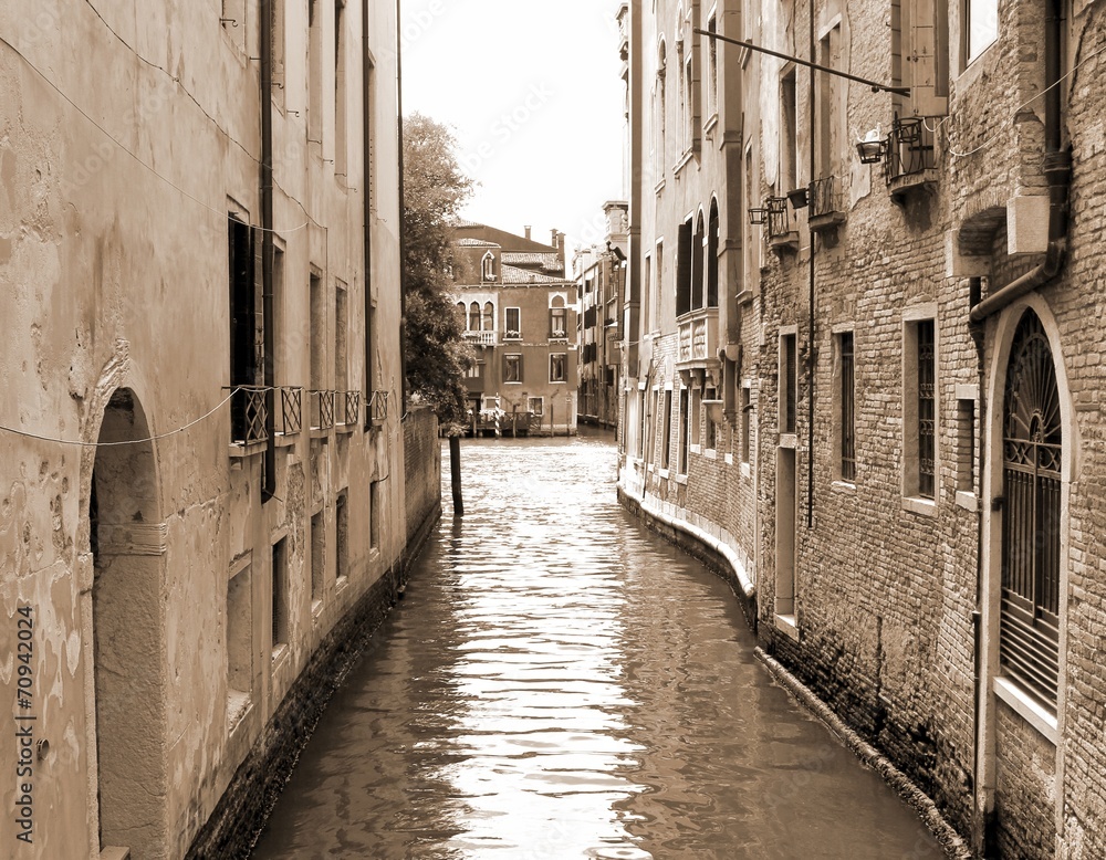 narrow navigable canal in Venice in Italy sepia