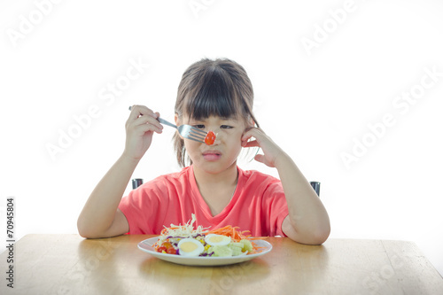 Cute Asian girl refusing to eat vegetable