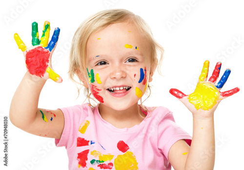 Portrait of a cute little girl playing with paints