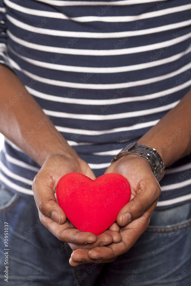 dark-skinned young man holding an object in heart shape dark-skinned young man holding an object in heart shape