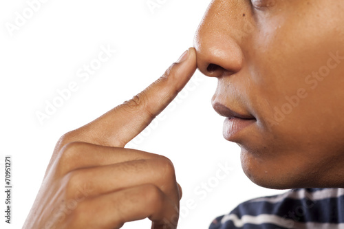 dark-skinned young man pressed his nose with his finger