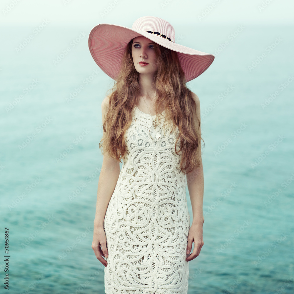 Beautiful woman in hat on the sea