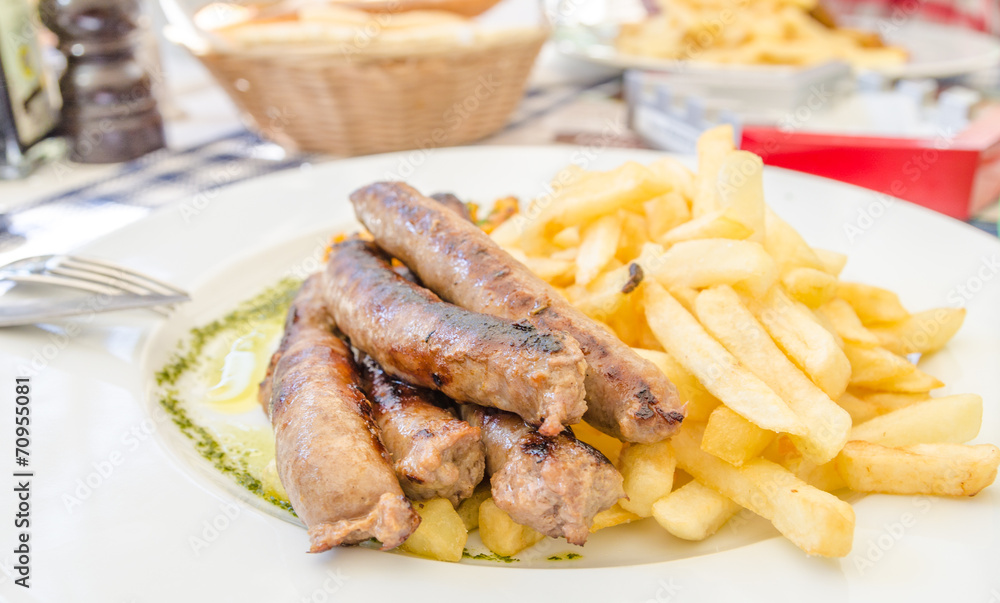 German sausages with french fries on a white plate