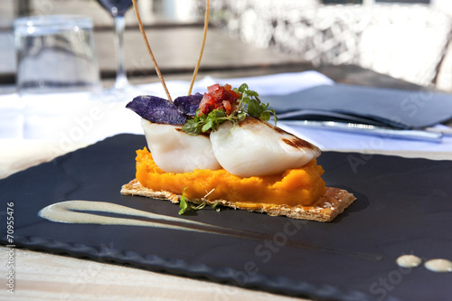 Fotografija Saint-Jacques scallops, carrots puree and biscuit on a slate