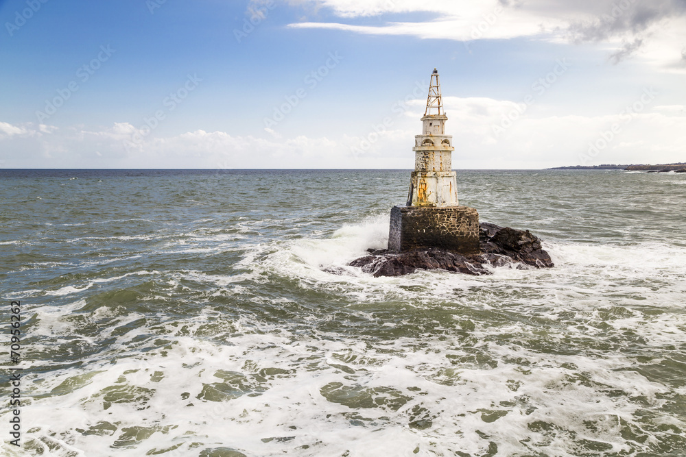 Lighthouse on rock in sea