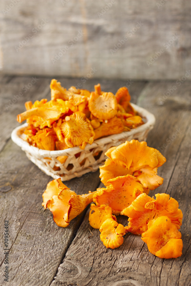 chanterelles in basket on wooden background chanterelles in basket on wooden background